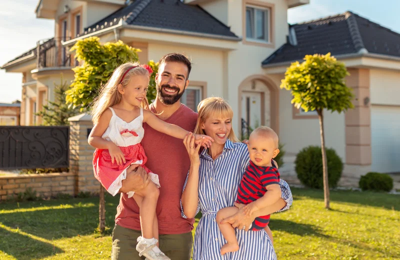 Happy Family Standing Outside Home